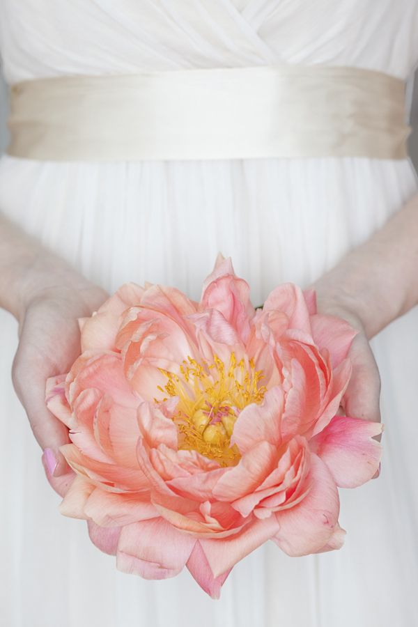 Bride holding a big pink flower- wedding photo by top Canadian wedding photographer Rebecca Wood